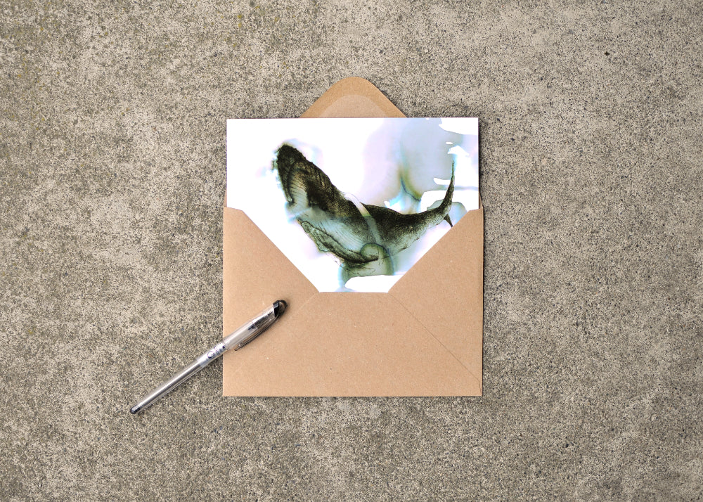 Ink and seawater drawing of a humpback whale. Card it featured with a pen and envelope.