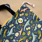 Pin back button with two imaginative "Avocado whales" on a cloth bag.